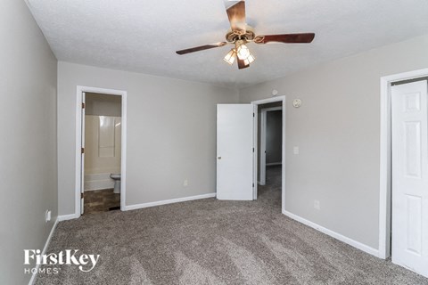 a living room with carpet and a ceiling fan