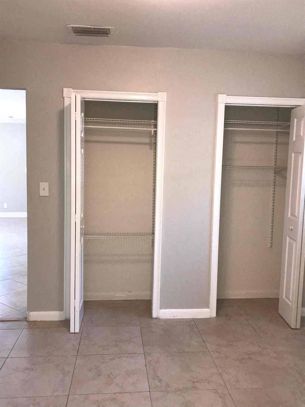 Two white closet doors in a room.