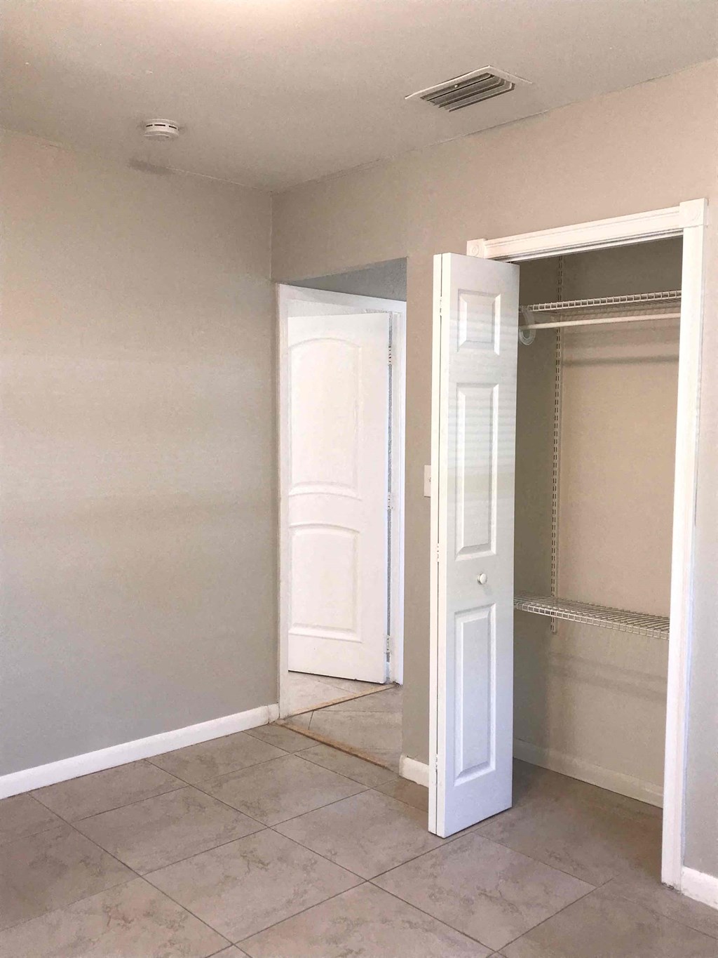A room with a white door and a white closet.