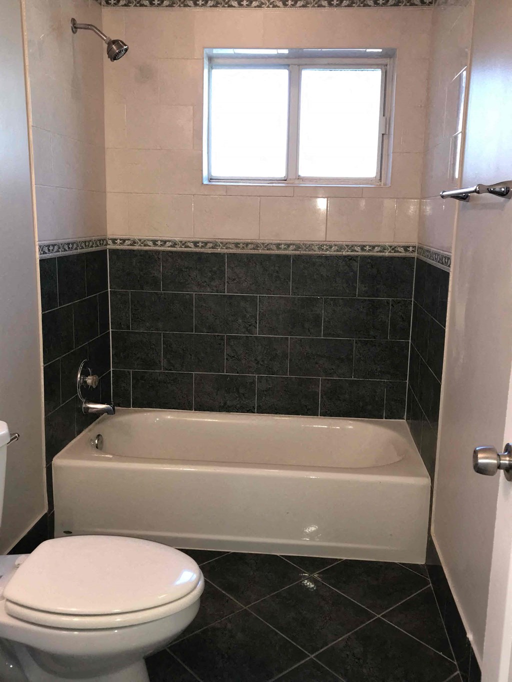 A white toilet sits next to a bathtub in a bathroom.