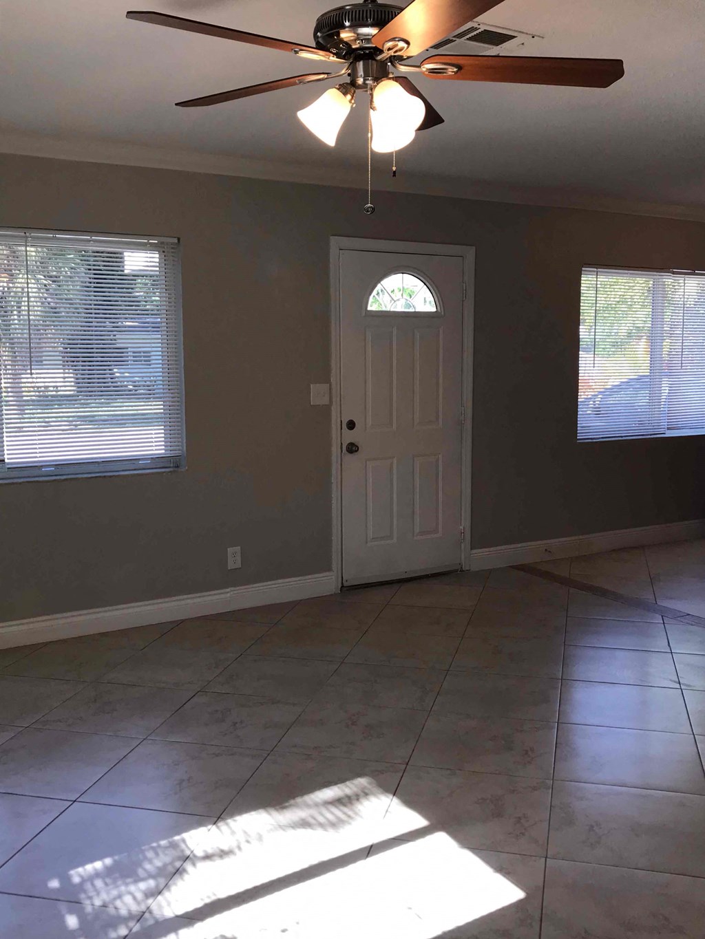 A room with a ceiling fan and a door.