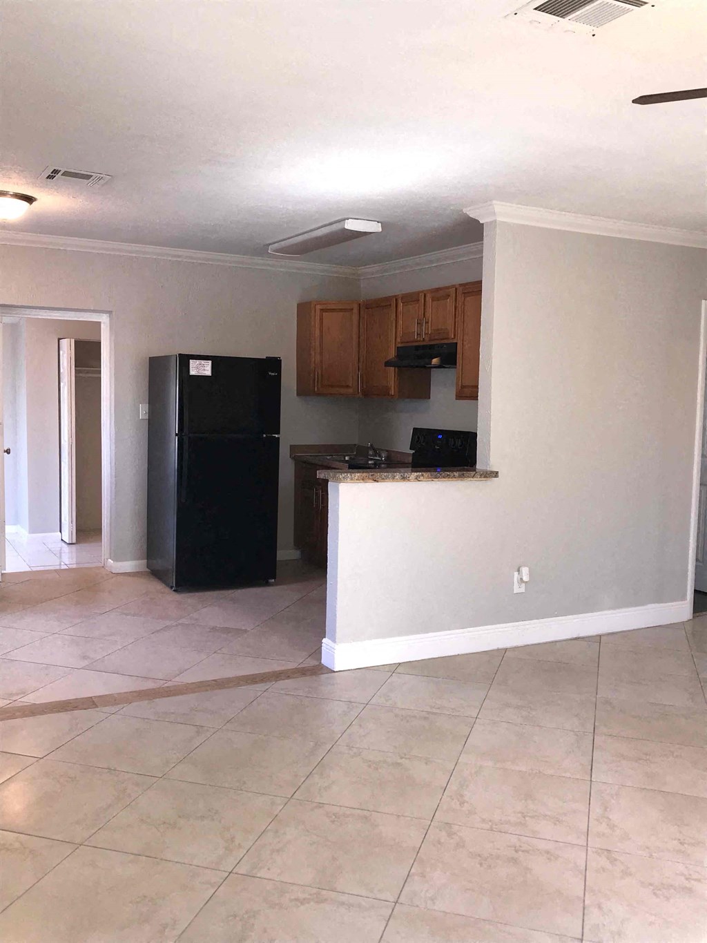 A kitchen with black appliances and wooden cabinets.