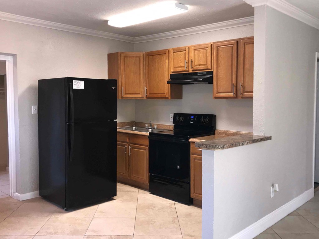 A kitchen with black appliances and wooden cabinets.