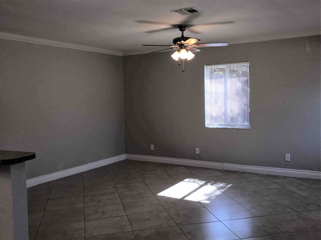 A room with a ceiling fan and a window.