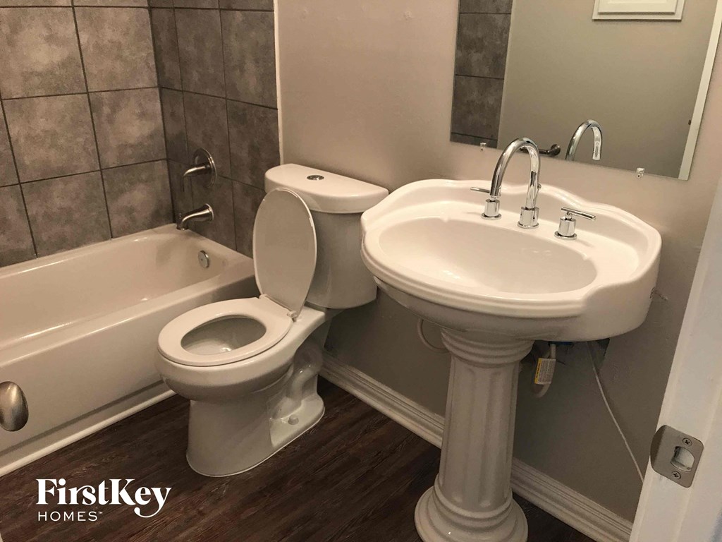 a bathroom with a toilet and a sink and a tub