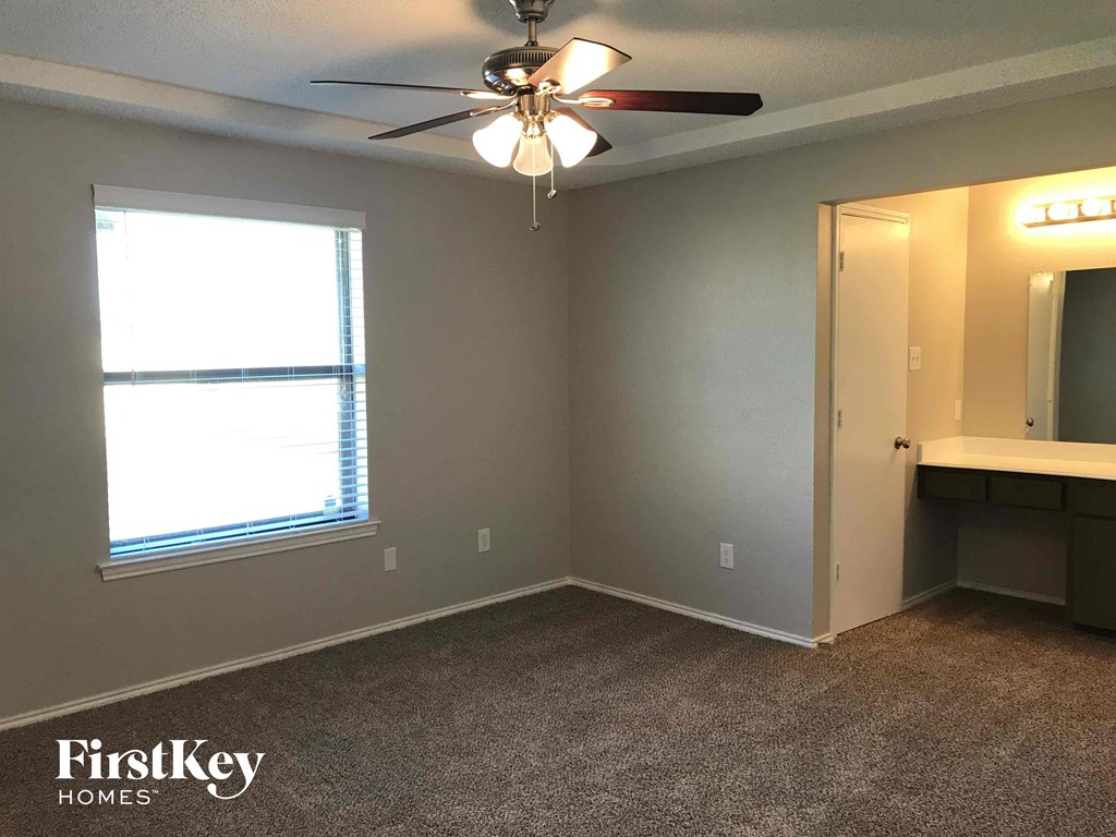 an empty room with a ceiling fan and a window