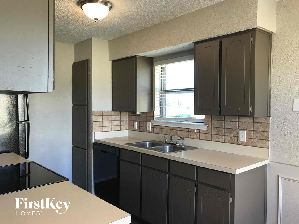 an empty kitchen with a sink and a window