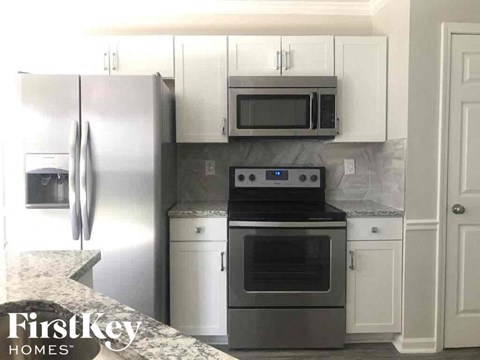 a kitchen with stainless steel appliances and white cabinets