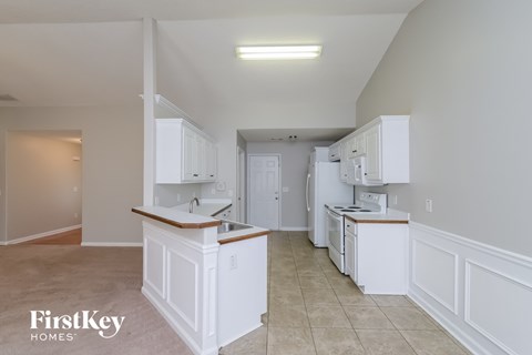 A kitchen with white cabinets and a counter top.