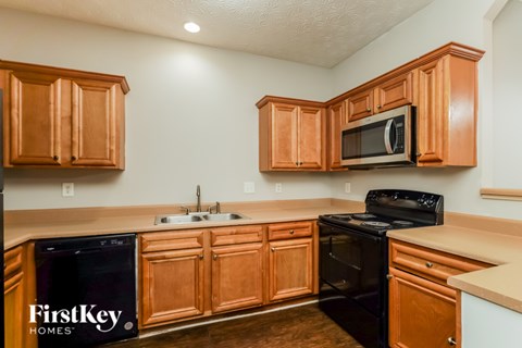 A kitchen with wooden cabinets and black appliances.