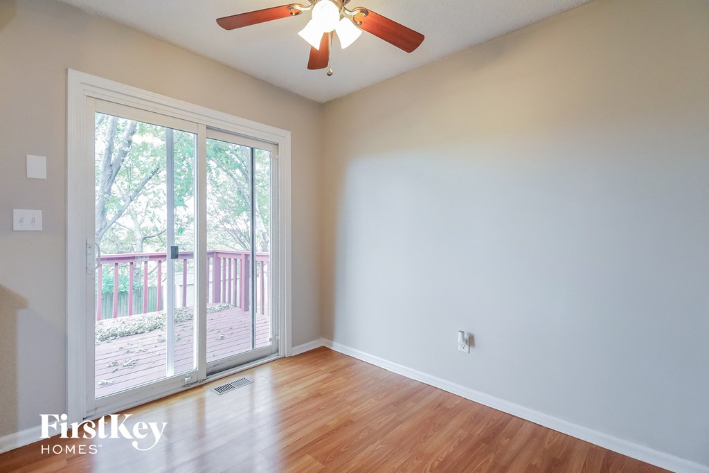 a living room with a ceiling fan and a sliding glass door