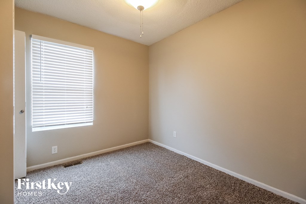 a empty room with carpet and a window