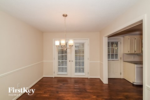 A room with a kitchen area in the background.