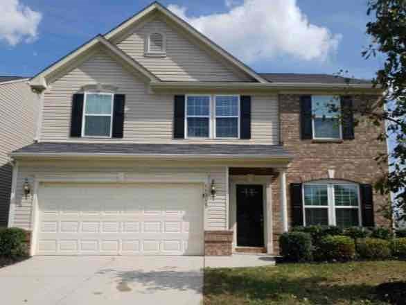 A house with a garage door and a brick chimney.