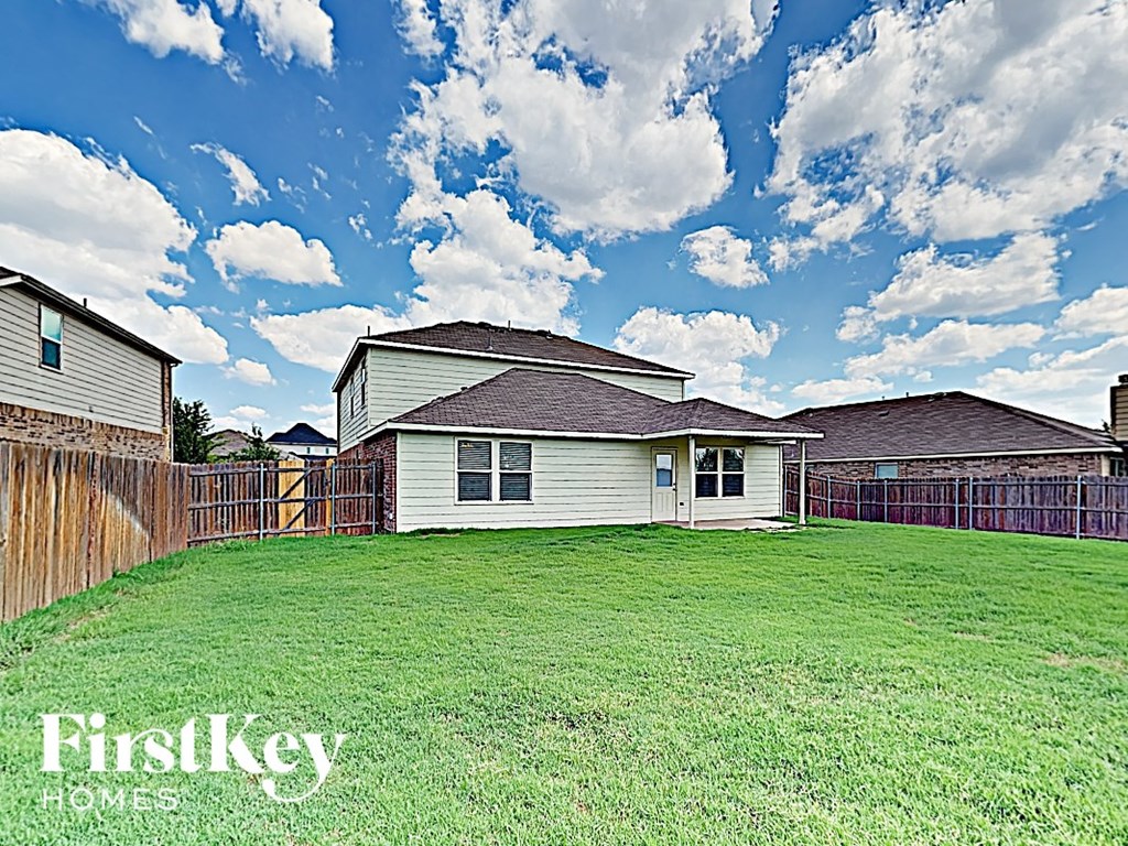 A house with a fence and a grassy yard is for sale.