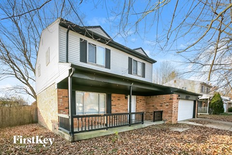 A house with a brick wall and a porch.