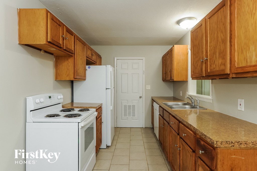 A kitchen with wooden cabinets and a white stove.
