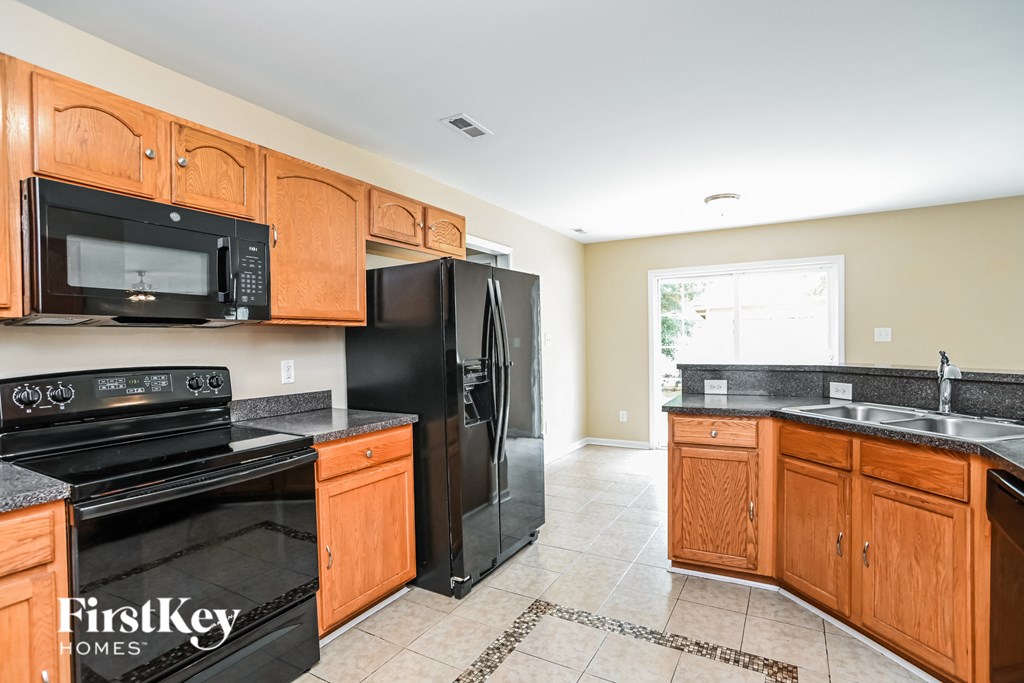 a kitchen with black appliances and wooden cabinets