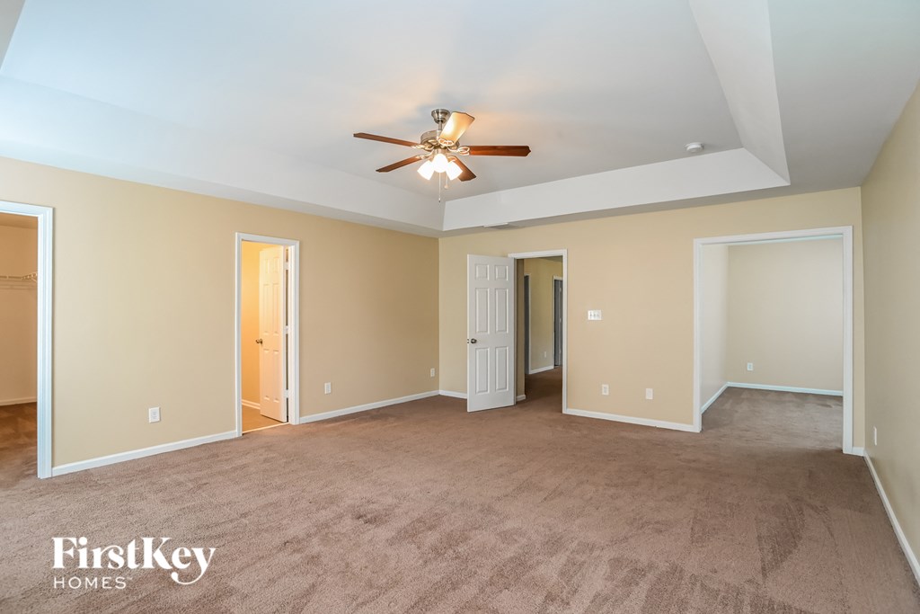 a living room with carpet and a ceiling fan