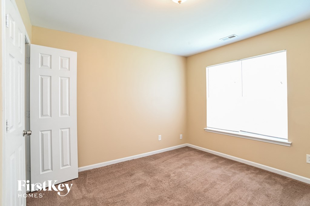 a room with carpet and a door and a window
