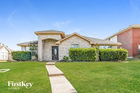a house with a lawn and a sidewalk in front of it