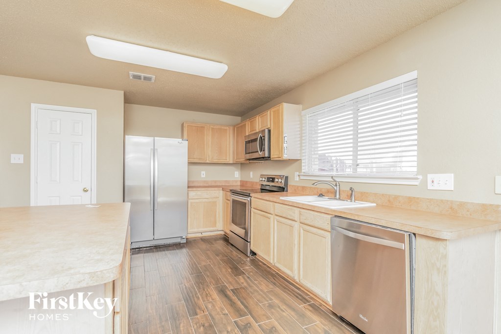 a kitchen with wooden cabinets and stainless steel appliances