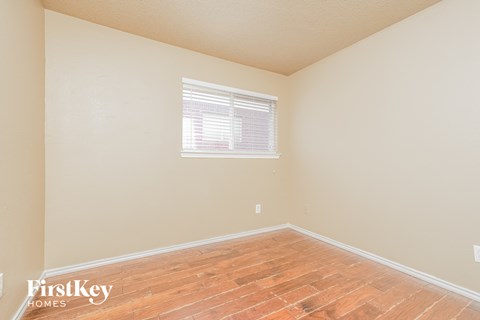 a bedroom with wood floors and a window