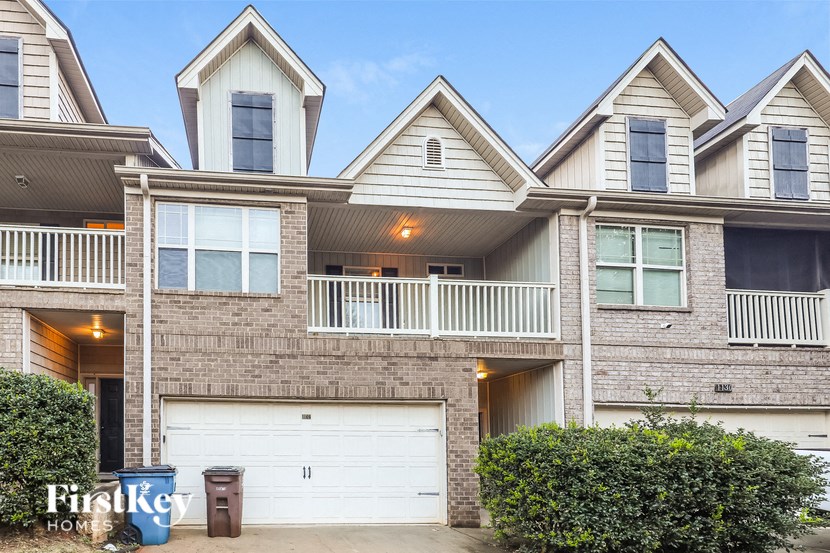 a brick house with a white garage door in front of it