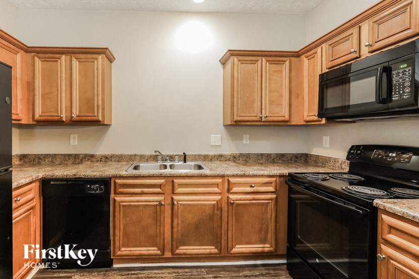 a kitchen with black appliances and wooden cabinets