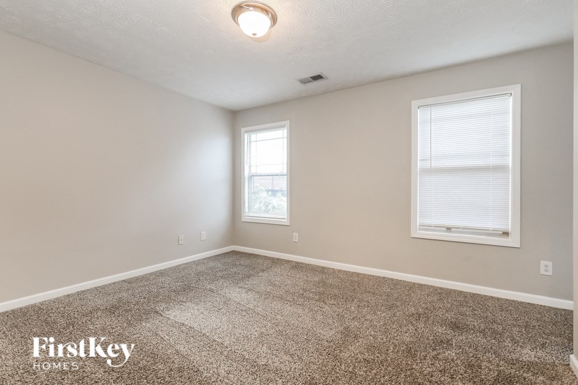 the living room of a home with carpet and a window