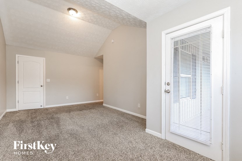 an empty living room with a door to a closet