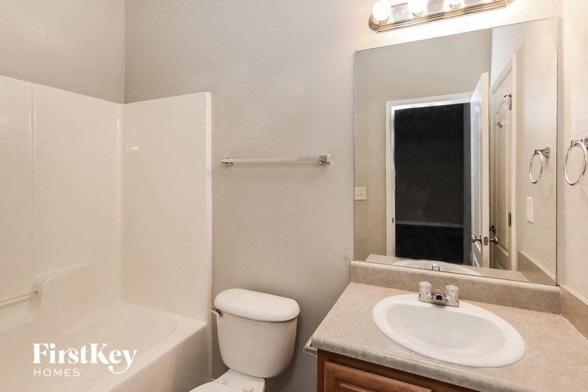 a bathroom with a sink toilet and a mirror