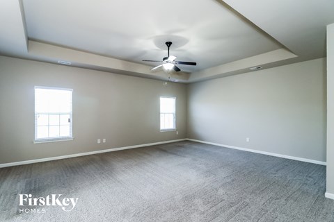 a living room with carpet and a ceiling fan