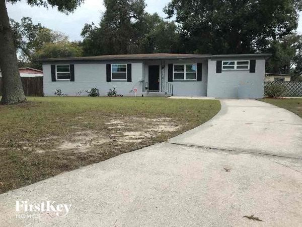 a small white house with a sidewalk in front of it