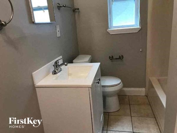 a bathroom with a toilet and a sink and a window