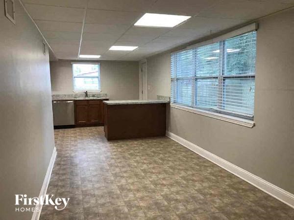 an empty room with a kitchen and a large window