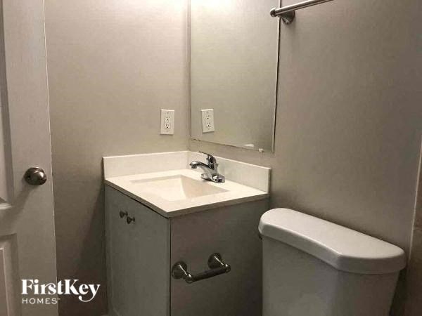 a bathroom with a toilet and a sink and a mirror