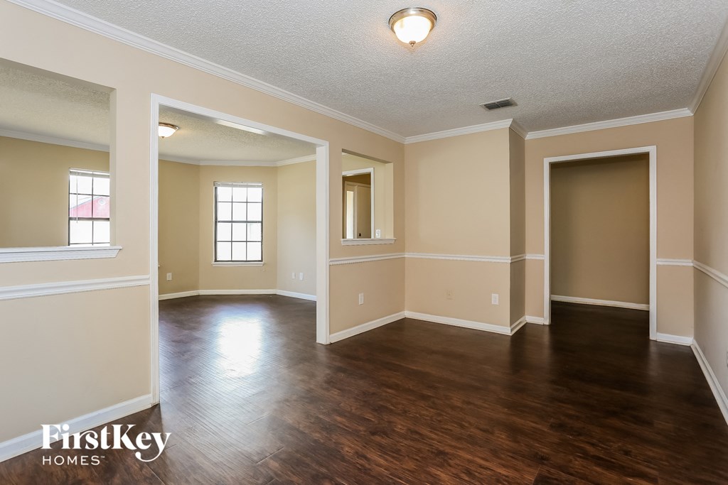 the living room and dining room of an empty house