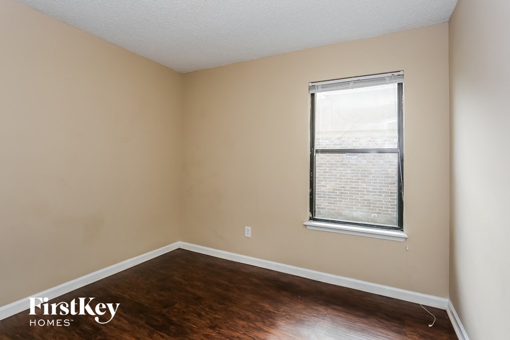 a bedroom with wood flooring and a window