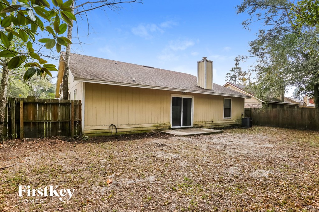 the back of a house with a yard and a wood fence