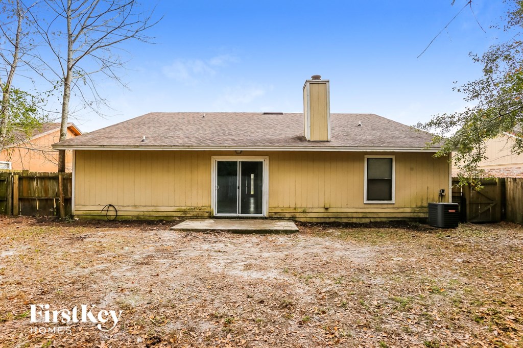 the front of a yellow house with a yard and a backdoor