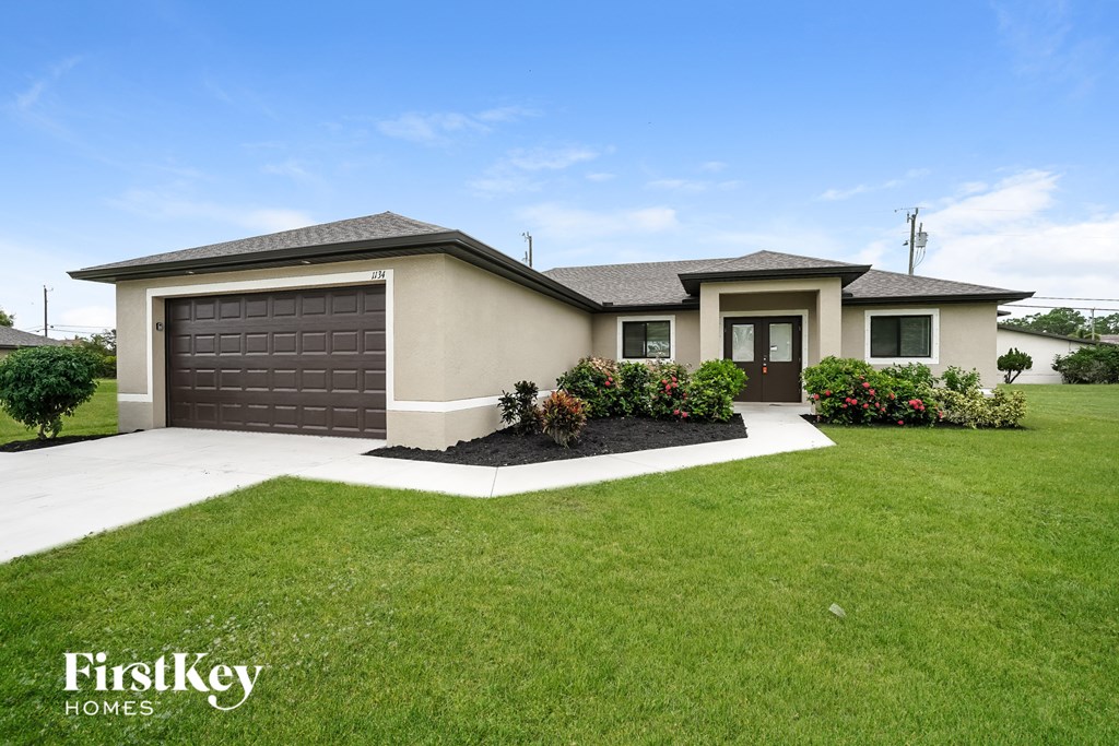 a house with a lawn and a driveway and a garage door