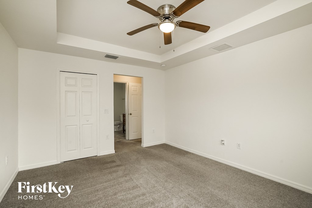 a living room with carpet and a ceiling fan