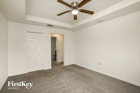 a living room with carpet and a ceiling fan