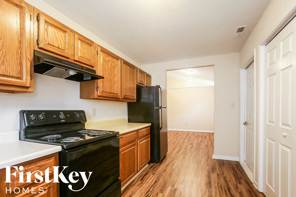 a kitchen with wood flooring and black appliances