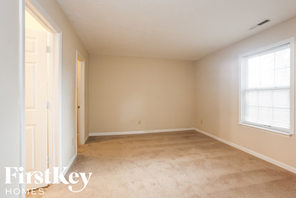 a bedroom with a carpeted floor and a window