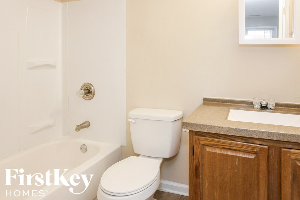a bathroom with a toilet and a tub and a sink