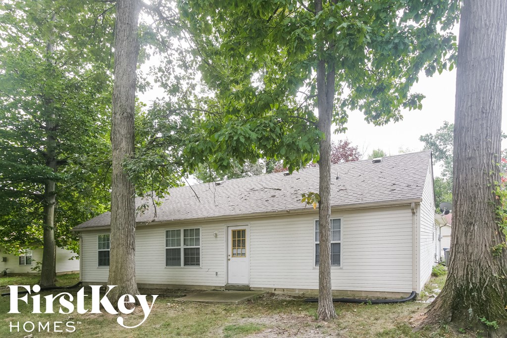 a small white house with trees in front of it
