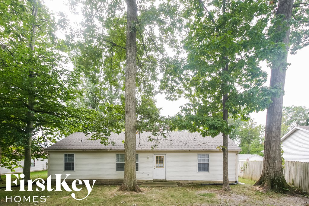 a small white house with trees in front of it