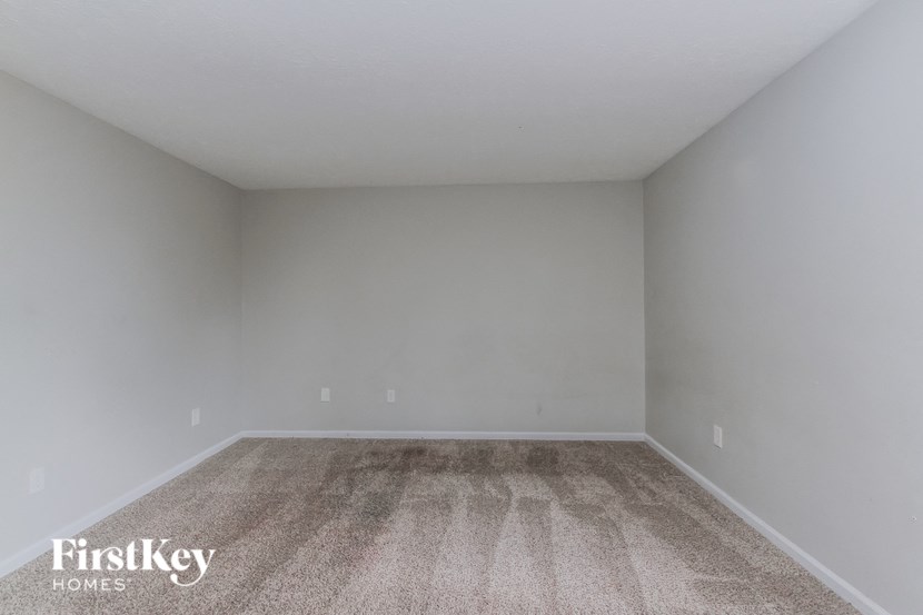 a empty room with carpet and white walls